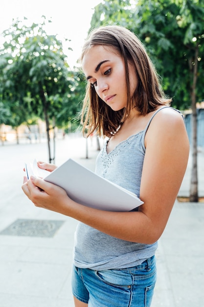 Menina segurando um livro na rua