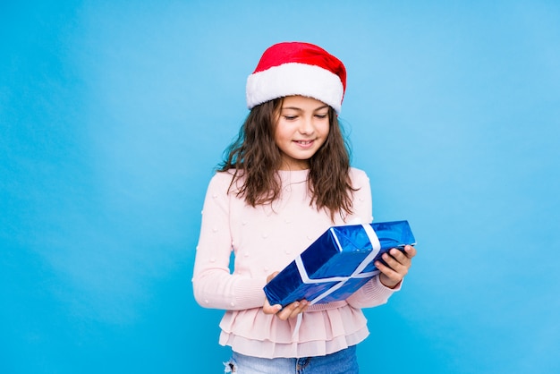 Menina segurando um presente comemorando o dia de Natal