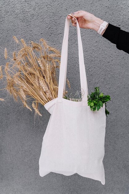 Menina segurando um saco de pano com espigas de trigo