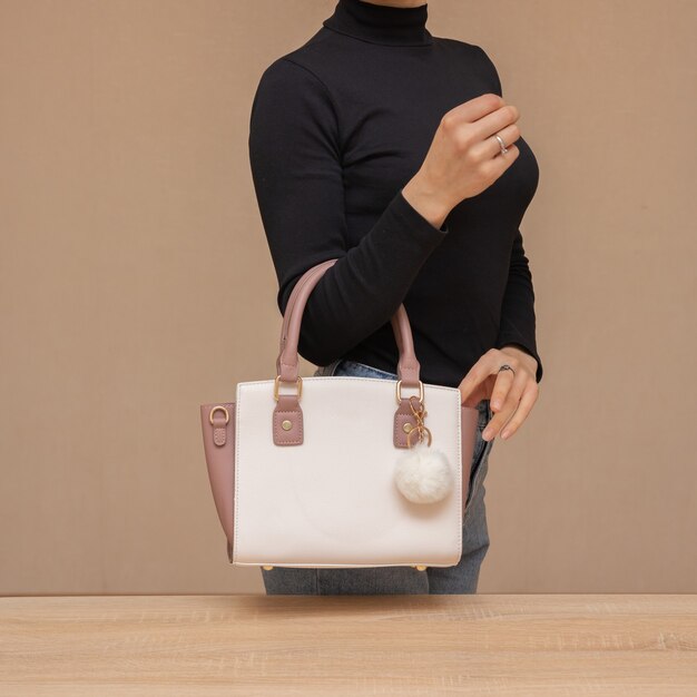 Foto menina segurando uma bolsa branca nas mãos