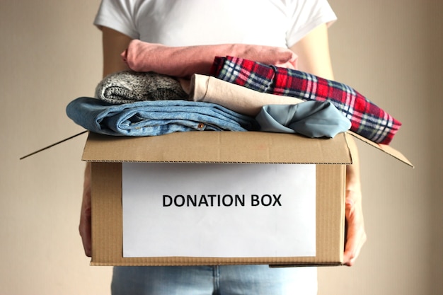Foto menina segurando uma caixa com um close de doações