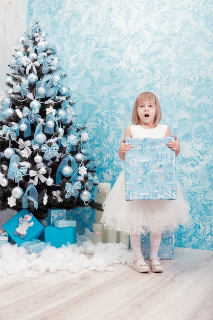 Menina segurando uma caixa de presente de Natal mágica