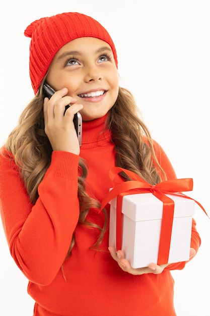 Menina, segurando uma caixa de presente e falando ao telefone em um branco