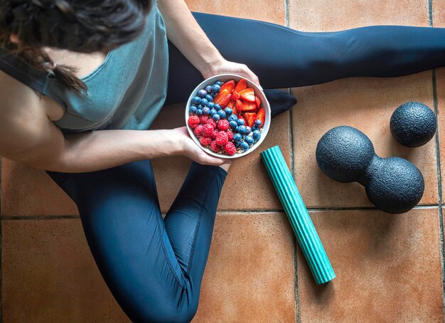 Menina segurando uma xícara com frutas