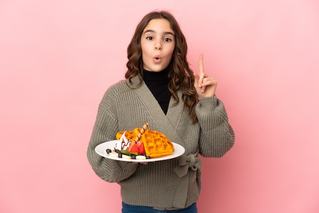 Menina segurando waffles isolados