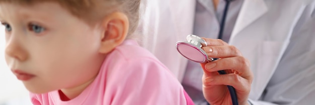 Menina sendo examinada pelo pediatra, criança calma, esperando pacientemente na consulta