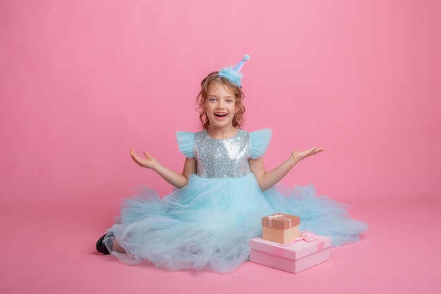 menina sentada comemorando aniversário em fundo rosa, lindo vestido de princesa