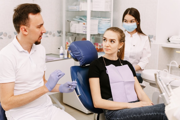Menina sentada em uma cadeira no dentista