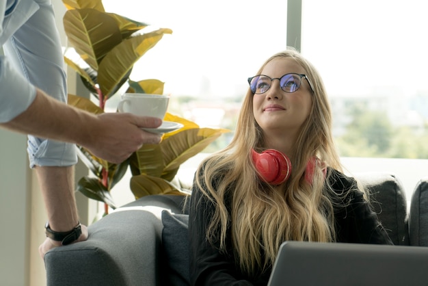 Menina sentada no sofá com fones de ouvido vermelhos relaxando e felicidade no apartamento