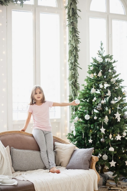 Menina sentada no sofá em casa durante o Natal