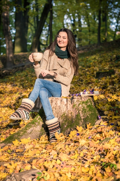 Menina sentada no tronco de árvore