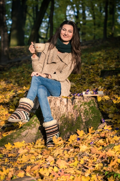 Menina sentada no tronco de árvore