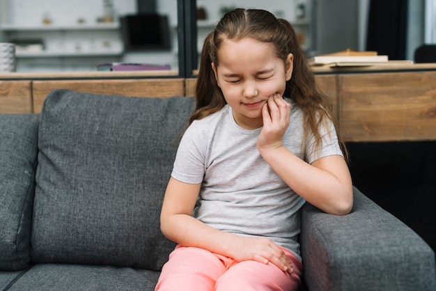 Menina, sentando, cinzento, sofá, sofrimento, toothache