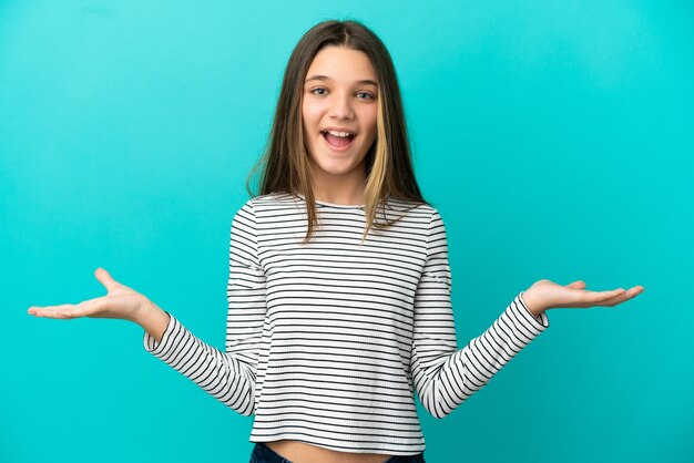 Menina sobre fundo azul isolado com expressão facial de choque