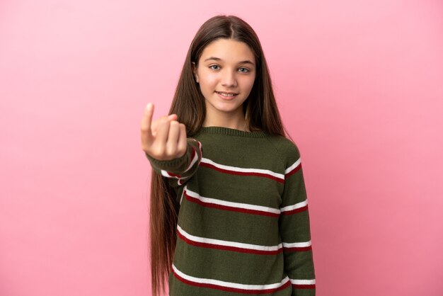 Menina sobre fundo rosa isolado fazendo gesto de vir