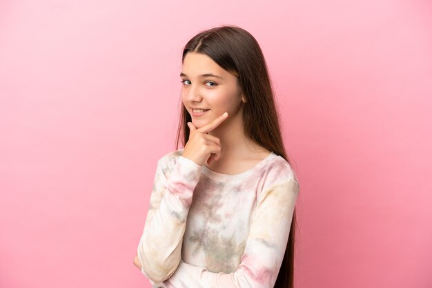 Menina sobre fundo rosa isolado feliz e sorridente