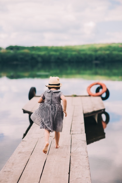 Foto menina solitária sentada no cais