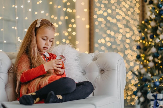 Menina solteira segurando um brinquedo de natal, falta de amor e atenção dos pais, sentindo-se solitária e abandonada, feriados tristes, infância infeliz