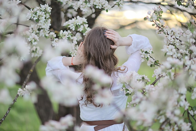 menina sonha vista traseira, menina feliz retrato de primavera no jardim florescendo, abril sazonal