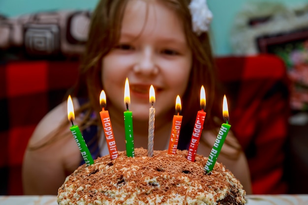 Menina, soprando velas bolo de aniversário, com velas