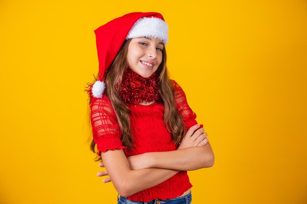 Menina sorridente bonitinha com roupa de natal e braços cruzados.