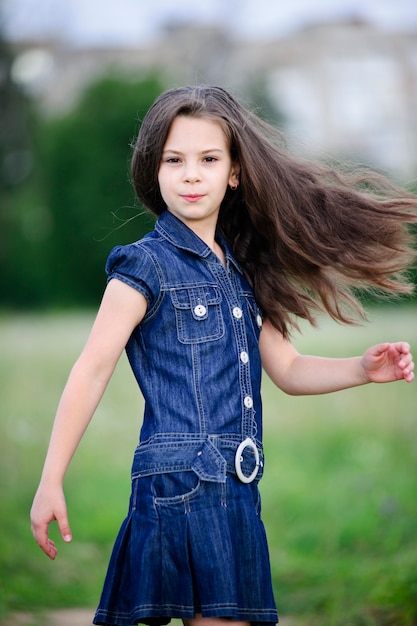 Foto menina sorridente bonitinha no campo verde na primavera.