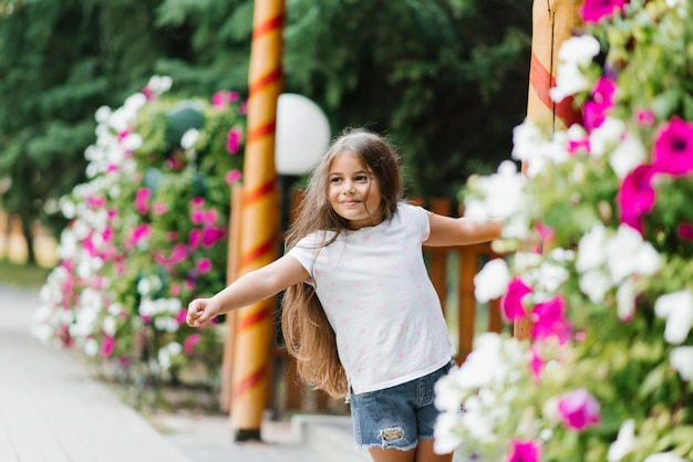 Menina sorridente caminha no parque em cores brilhantes