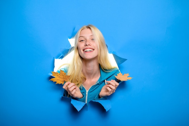 Menina sorridente com folhas de plátano humor outonal folha de plátano amarela menina feliz segurando a folha na mão outono