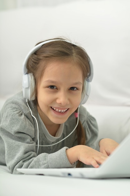 Menina sorridente com laptop em casa