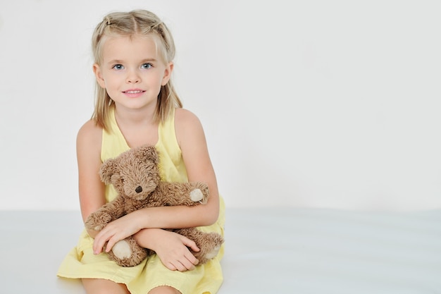 Menina sorridente com ursinho de pelúcia