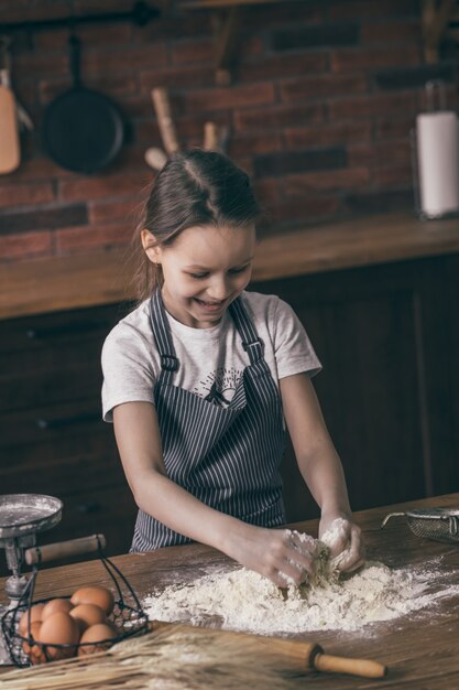 Menina sorridente, cozinhando com farinha