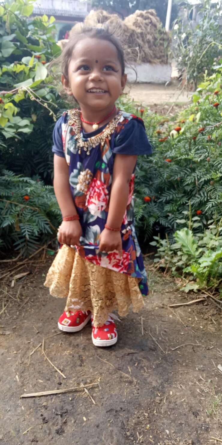 Foto menina sorridente de pé contra as plantas