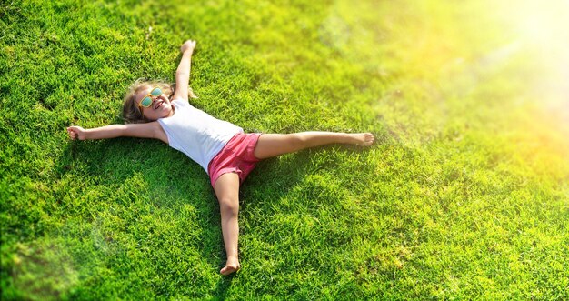 Foto menina sorridente deitada no prado de grama
