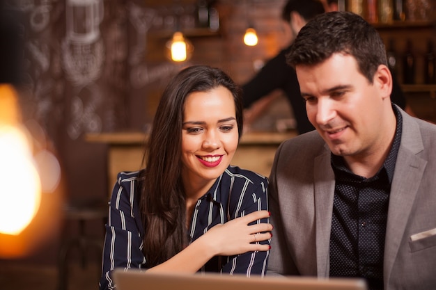 Menina sorridente e seu parceiro de negócios, tendo uma videochamada em um café. Negócios modernos. Boa concentração.