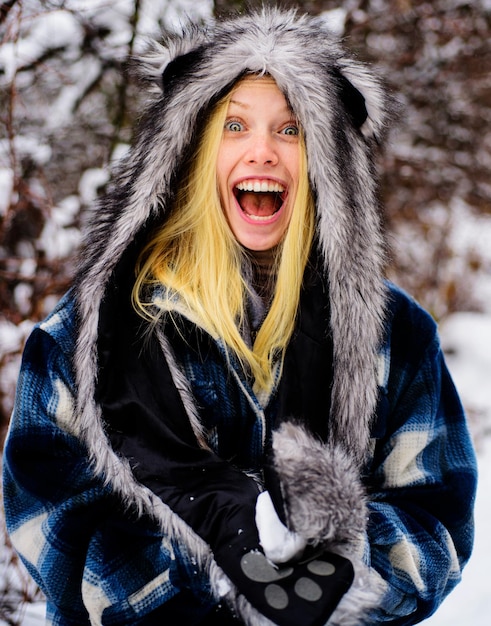Menina sorridente em roupas quentes com bola de neve linda jovem brincando com neve em winter park