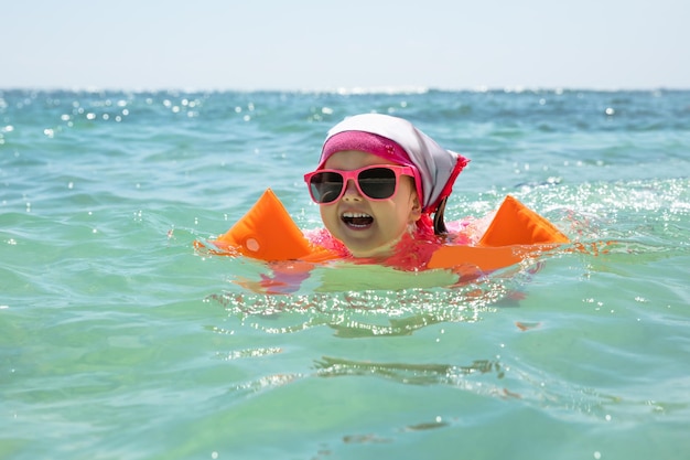 Menina sorridente nadando no mar