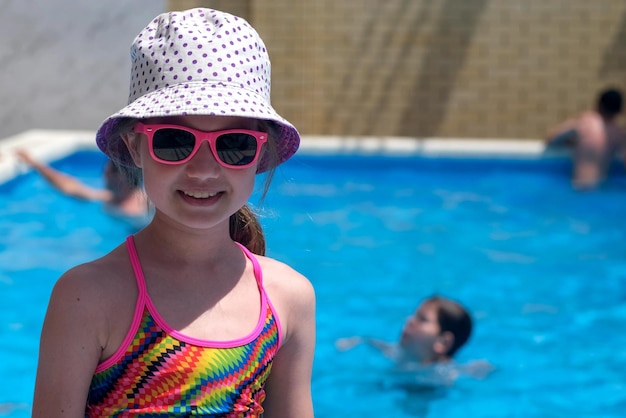 Menina sorridente no fundo da piscina em dia ensolarado Férias de acampamento de verão Copiar espaço