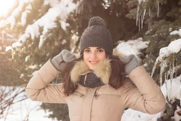 Menina sorridente no parque no inverno com muita neve ao redor