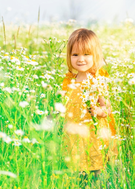 Foto menina sorridente num campo de flores silvestres brancas