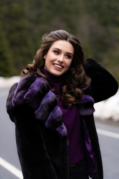 Menina sorrindo para a câmera na floresta de inverno