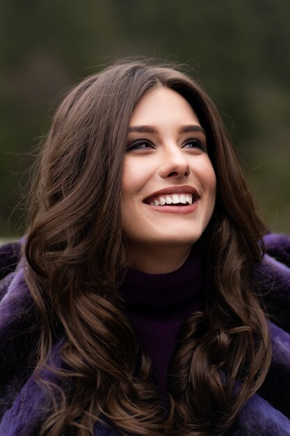 Menina sorrindo para a câmera na floresta de inverno