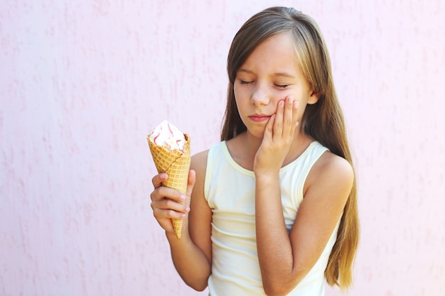 Menina tem uma dor de dente de sorvete frio.