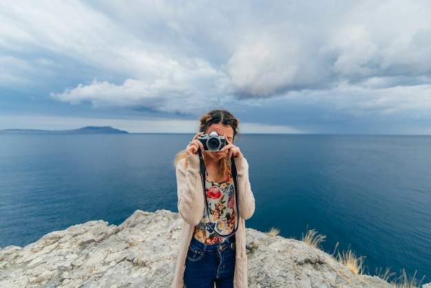 Menina tirando fotos ao ar livre em uma câmera