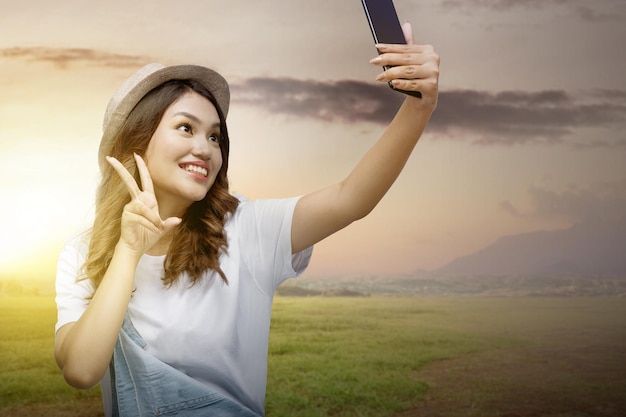 Menina tirando uma selfie com uma expressão de sorriso Cara de sorriso feliz Conceito do Dia Mundial do Sorriso