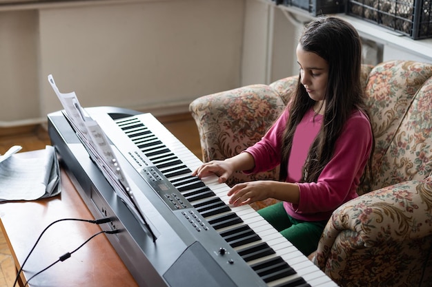 menina tocando em um novo sintetizador na sala antiga.