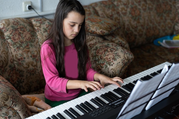 menina tocando em um novo sintetizador na sala antiga.