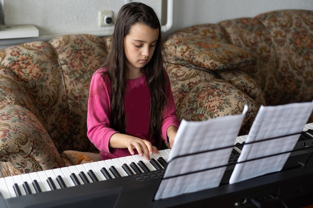 menina tocando em um novo sintetizador na sala antiga.