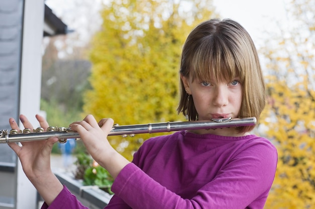 Menina tocando flauta ao ar livre