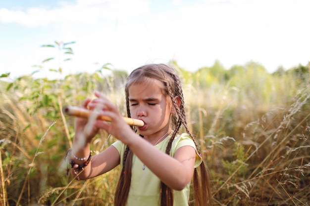 Menina tocando flauta no campo