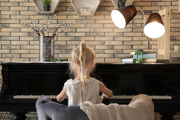 Menina tocando piano dentro de casa